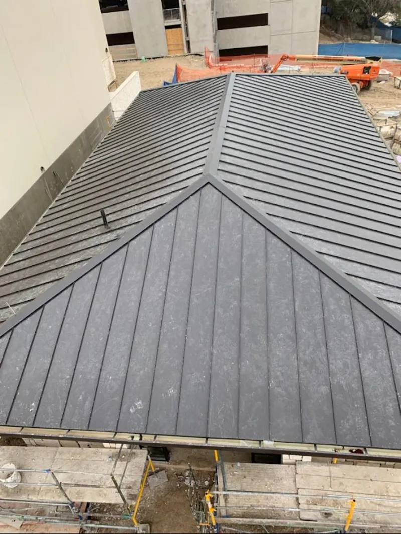 Commercial metal roof construction with crane equipment in Danbury